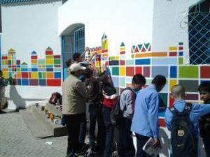تلاميذ مع الفنان التشكيلي اثناء رسم جداريات بمؤسسة تعليمية 